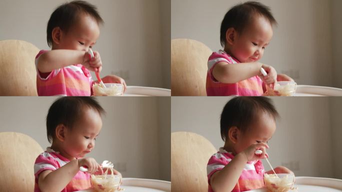 可爱小女孩学用勺子自己吃饭吃面条