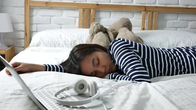 女人睡在床上厌倦了用笔记本电脑工作