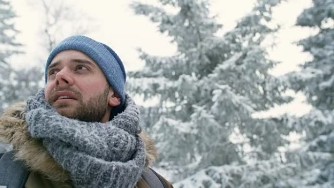 站在白雪皑皑的森林中的男性徒步旅行者