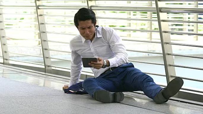 紧张的一天，年轻的商人坐在地板上拿着手机。