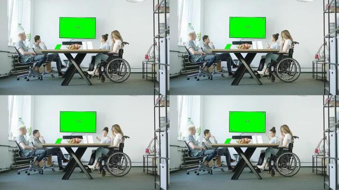 坐在轮椅上的年轻女子和她的展示团队与他们的导师讨论。创业公司