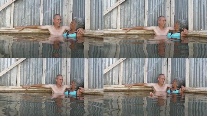 混合种族的高级夫妇享受热水游泳池