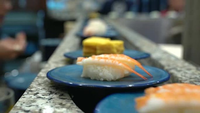 寿司和生鱼片。在传送带上滚动的寿司和生鱼片菜肴。日本传统生活方式。