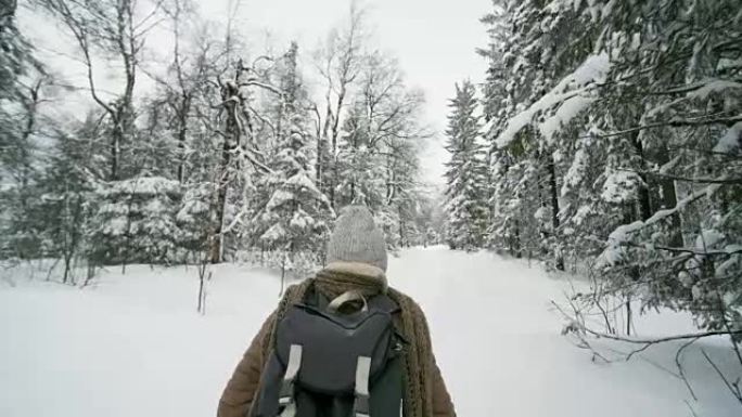 冬季的女性徒步旅行者在森林中行走