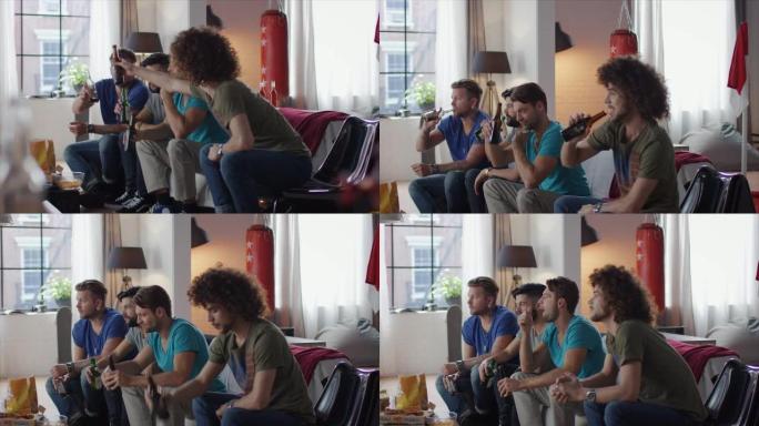男人们坐在沙发上看电视，碰着瓶子
