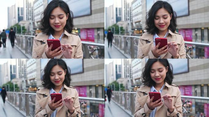 一位年轻的年轻亚洲妇女在城市使用手机