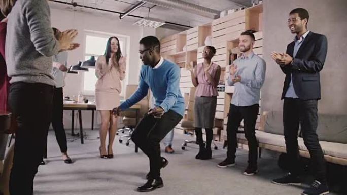 快乐的非洲裔美国老板在办公室团队建设派对上与员工共舞，庆祝团队成功慢动作