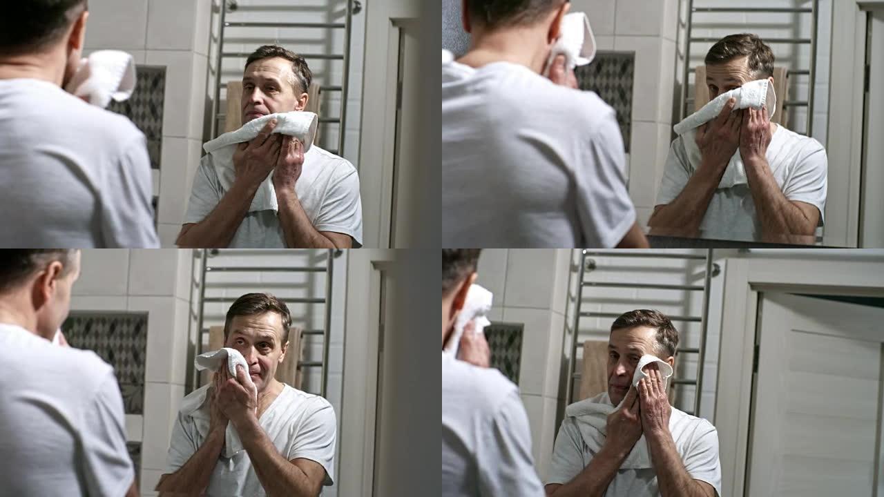 男子洗完后用毛巾擦脸