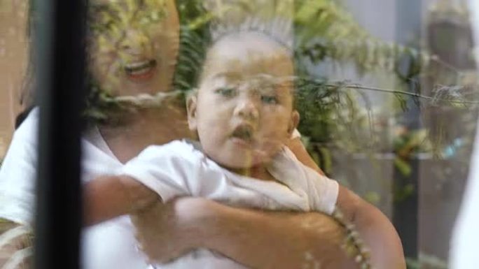 4k镜头亚洲母亲抱着和父亲与男婴在充满幸福生活的房间里玩耍的现代阁楼房屋，家庭和生活方式的概念