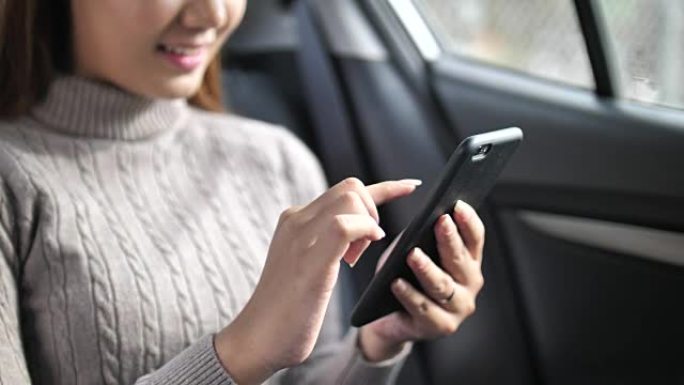 在汽车中使用智能手机的特写女人，慢动作