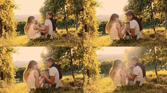 年轻夫妇在葡萄园里吃葡萄