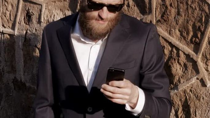 长胡子的好人用智能手机。