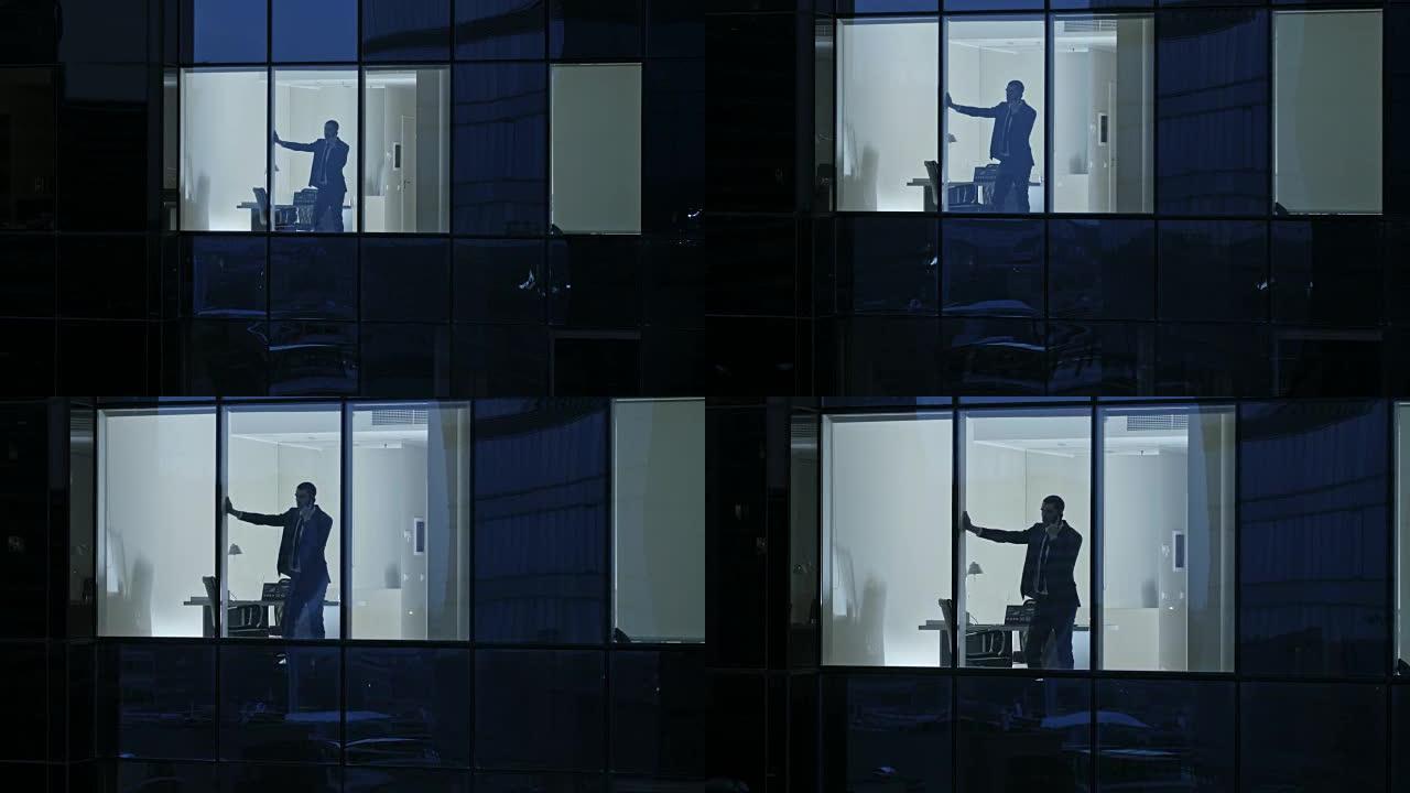 鸟瞰图: 从外面进入办公楼，商人使用手机并站在办公室窗户旁。美丽的飞拍金融商务区摩天大楼。