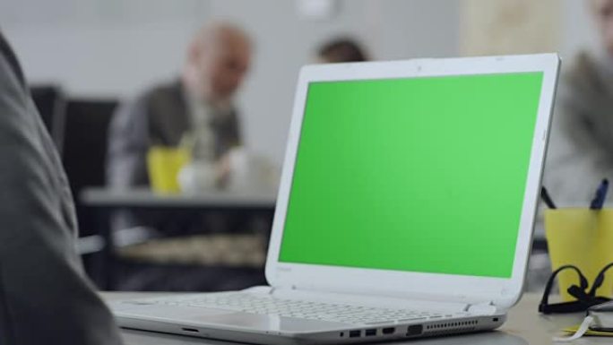 女性在绿屏笔记本电脑上打字