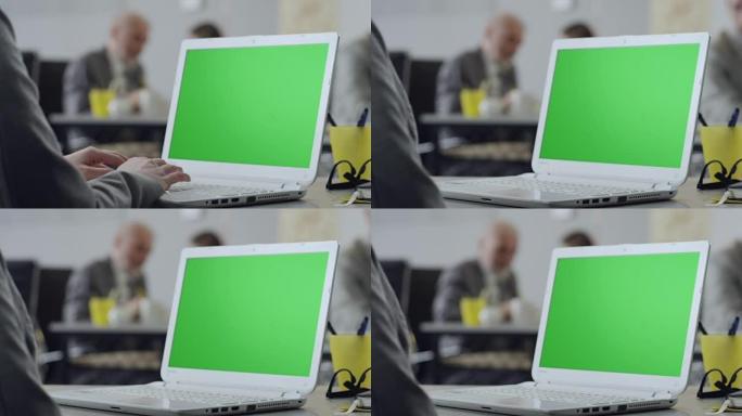 女性在绿屏笔记本电脑上打字