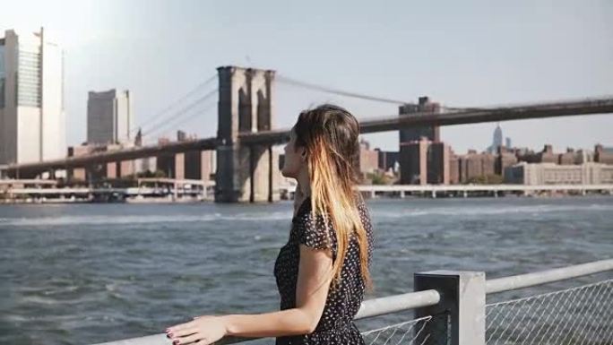 快乐放松微笑的长发高加索女孩走在曼哈顿天际线景观在阳光明媚的日子里通过电话交谈