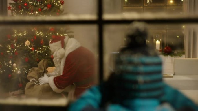 监视圣诞老人在圣诞树下分发礼物的男孩
