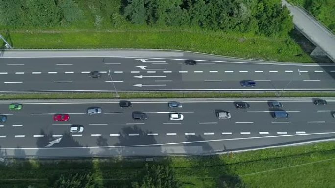 空中: 五颜六色的车辆沿着高速公路和混凝土立交桥下移动。