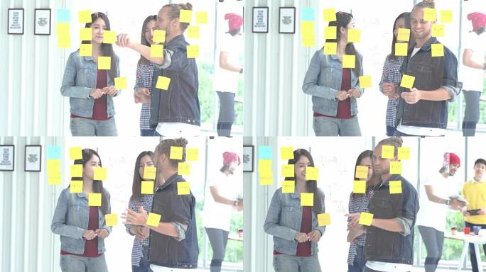 4k分辨率多民族创意团队头脑风暴智能休闲装站在办公室玻璃墙后面开会