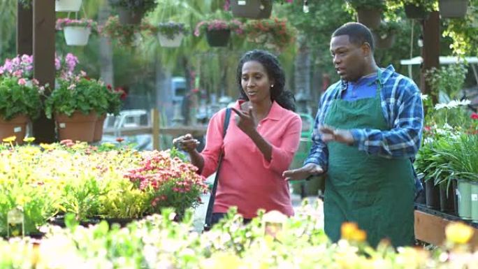 植物苗圃中的非裔美国人工人帮助客户