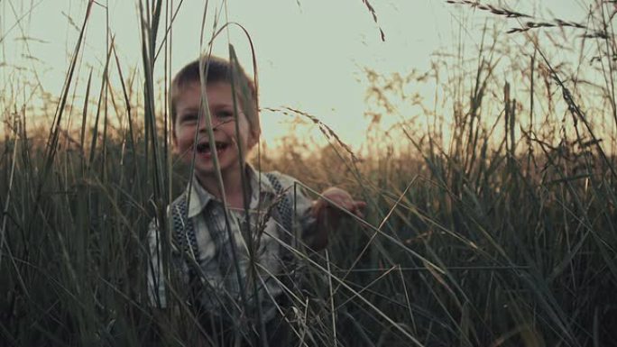 慢动作男孩在草地上笑得很开心