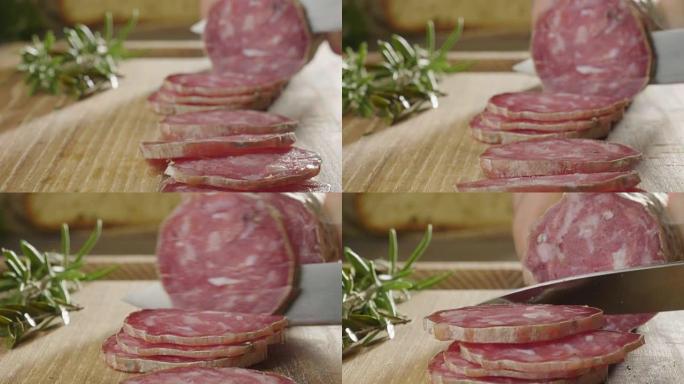 一位经验丰富的厨师在专业厨房切调味的.Il意大利萨拉米香肠是用专业的刀切非常薄的切片。