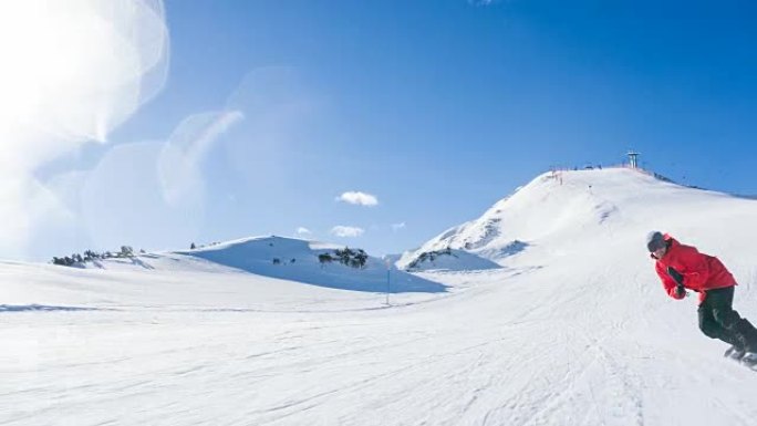 滑雪者在阳光明媚的日子里沿着滑雪坡骑行，背景是滑雪缆车