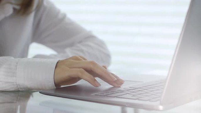 年轻的商务女性使用笔记本电脑触摸板