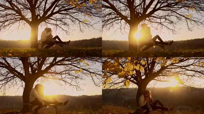 日落时分坐在树下的浪漫情侣