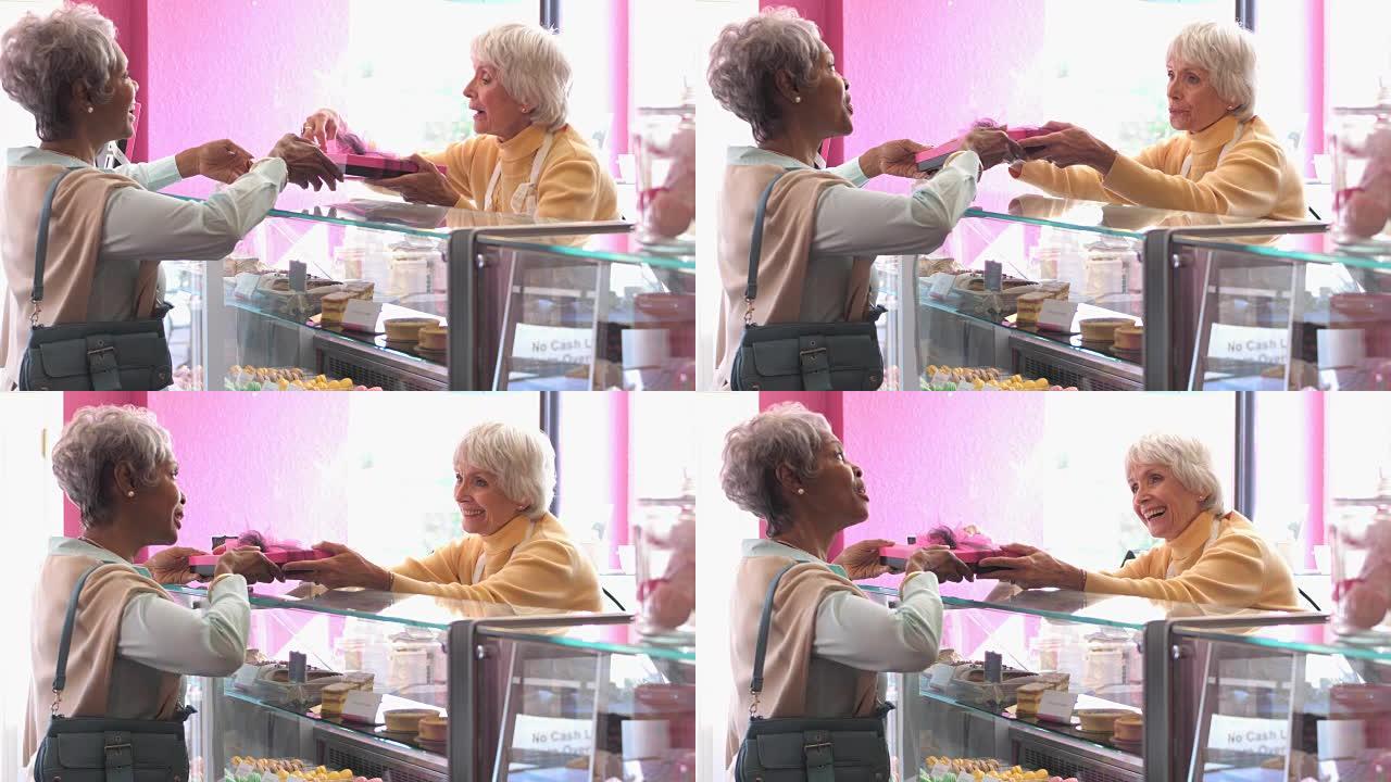 在糕点店工作的高级妇女帮助客户