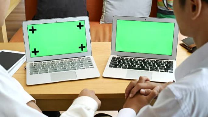 两人讨论与绿屏笔记本电脑