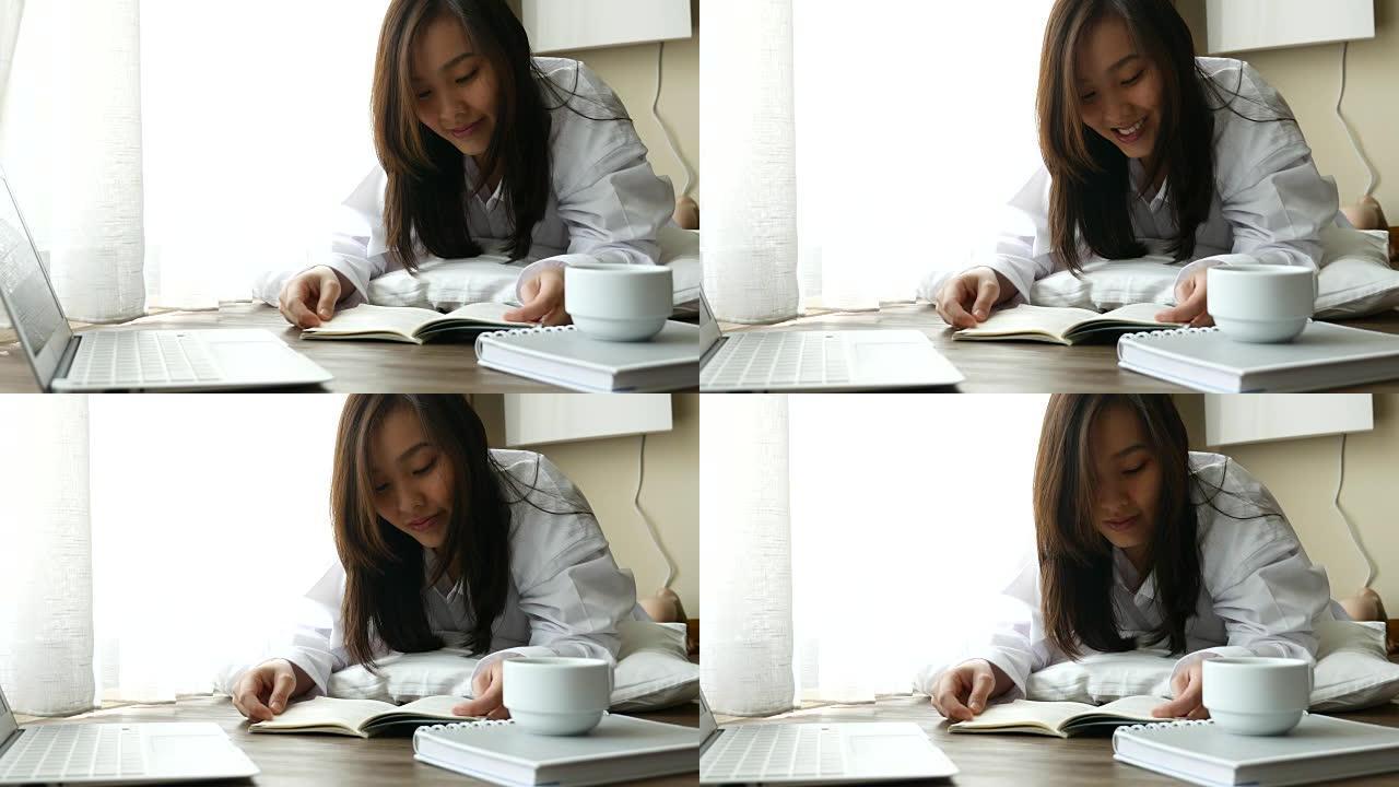 年轻的亚洲女性在家放松阅读书籍生活理念。