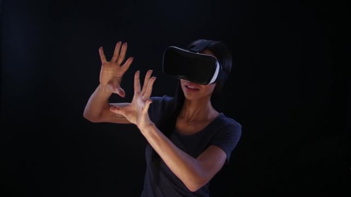 使用虚拟现实眼镜的女人。推开巨大的想象物体