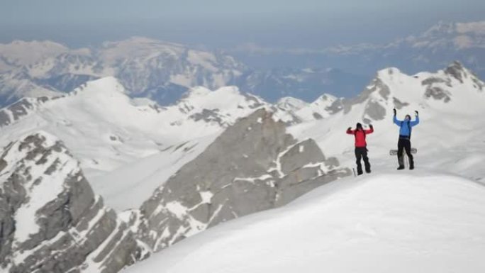 登山者在白雪覆盖的山峰上欢呼雀跃