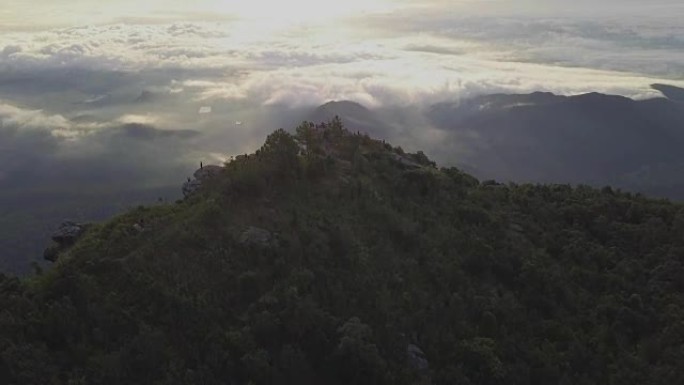 在Ramkhamhaeng国家公园Khao Luang的Narai悬崖上，旅行者和日出的鸟瞰图