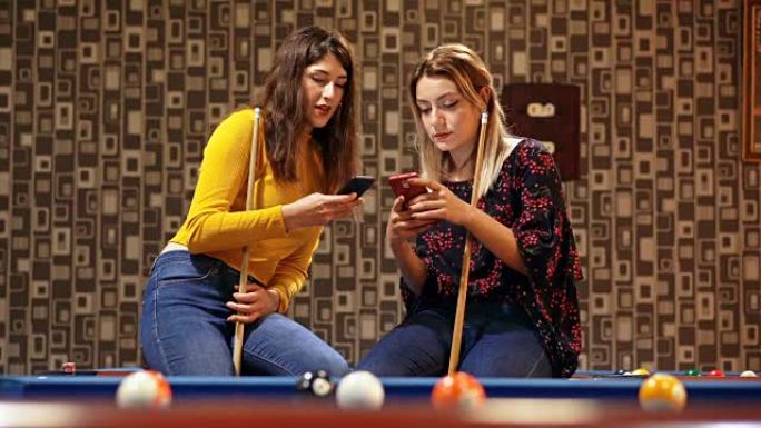 4k女人在酒吧使用智能手机。斯诺克室背景
