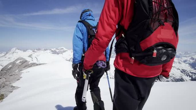 登山者在白雪覆盖的山峰上行走