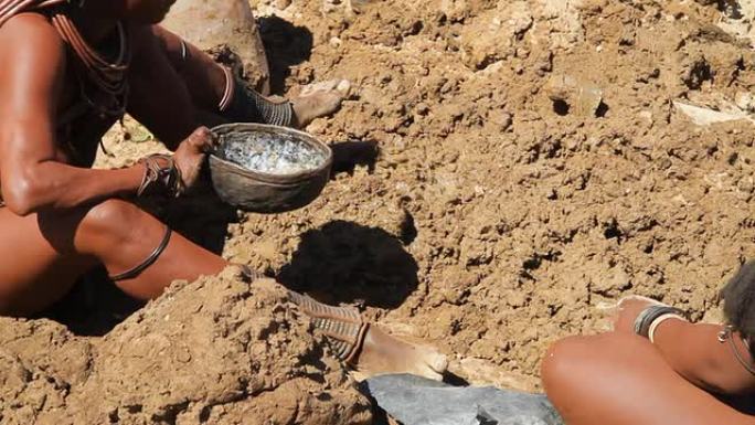 CU Ovahimba妇女浇水土壤