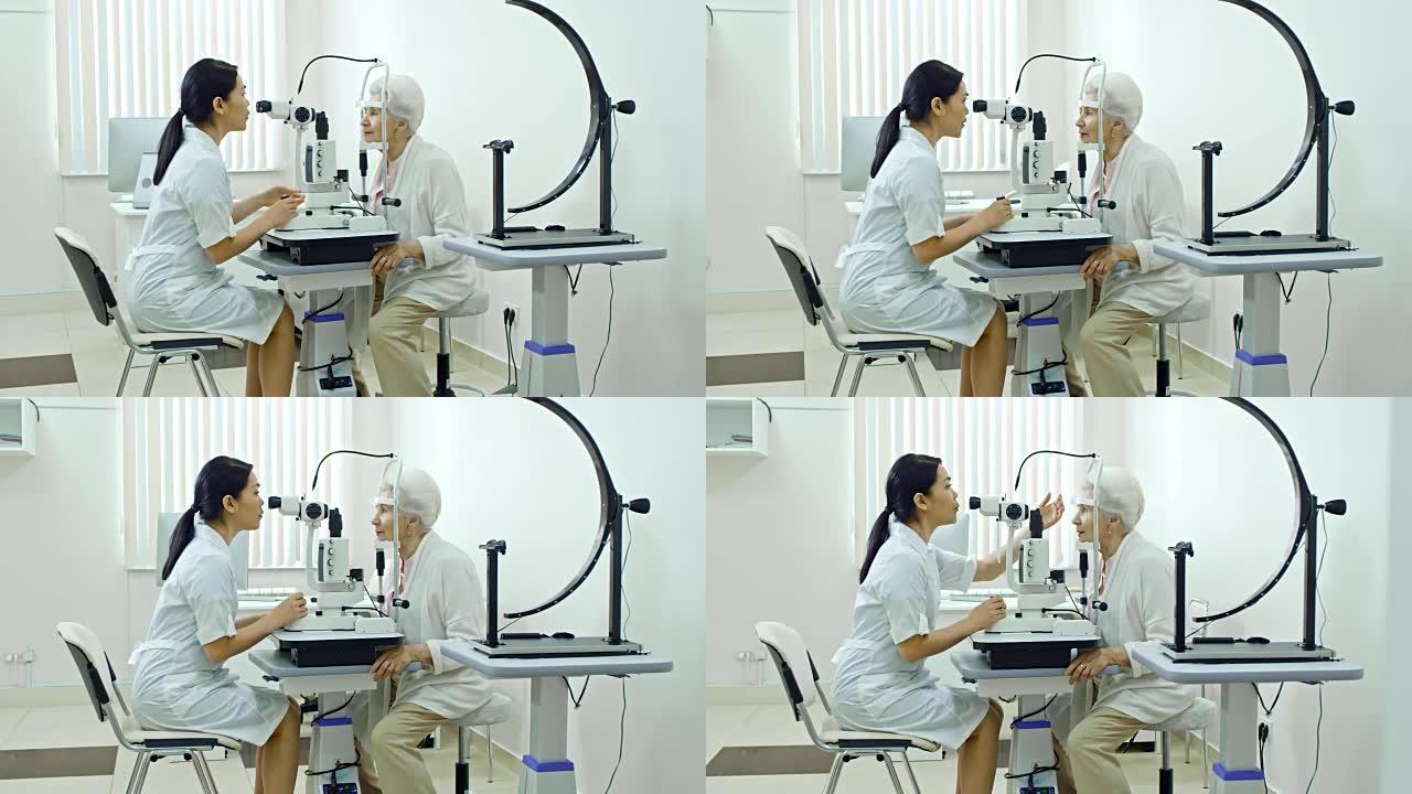 女性验光师在诊所与高级女性一起工作