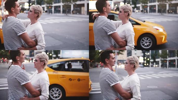 慢动作年轻男女站在一起拥抱在纽约街道口，黄色出租车经过