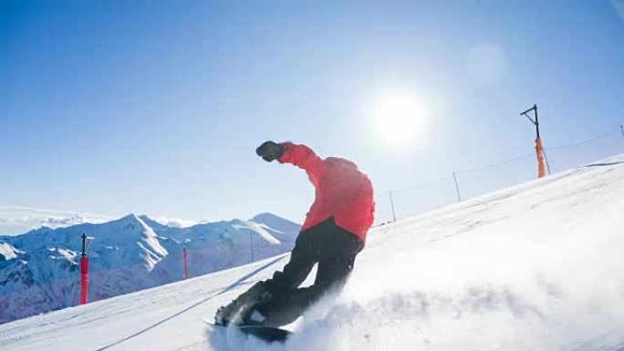 滑雪者骑着滑雪道在转弯的同时喷洒雪，背景中的山脉