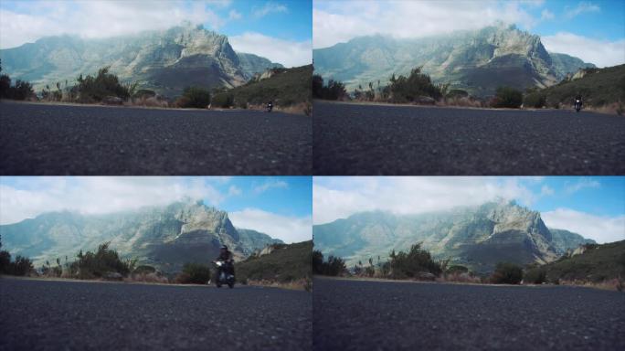 男子在山路上骑摩托车