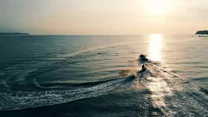 海上日落。两艘摩托艇在海湾中冲浪
