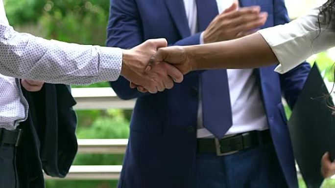 黑白双手与商务服装在现代握手中相互表达友谊和尊重。