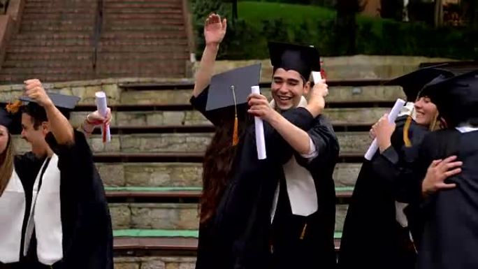 庆祝他们刚刚毕业的拉丁美洲学生拥抱并互相击掌