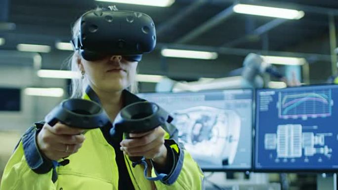 工厂: 戴着虚拟现实耳机和手持控制器的女工业工程师，她在cad软件中使用VR技术进行工业设计，开发和
