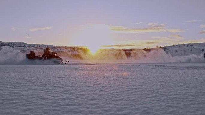 挪威日落时骑雪地车的SLO MO游客