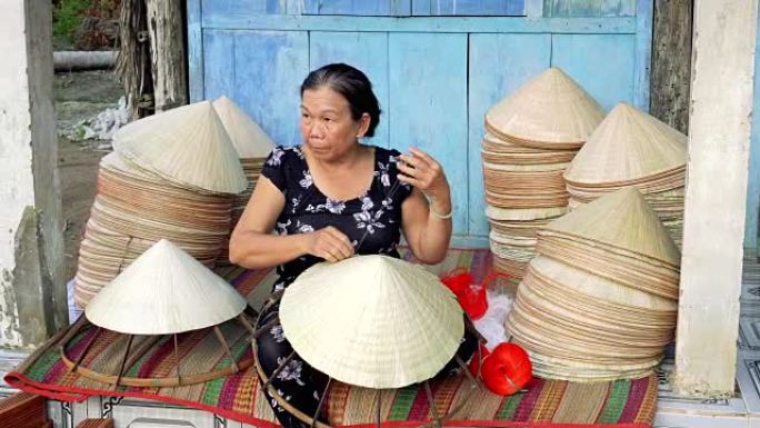 越南坎托省Ap Thoi Phuoc村的旧传统房子里制作传统越南帽子的4k镜头，传统艺术家概念
