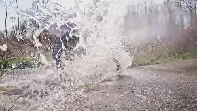 SLO MO山地自行车手在水坑中漂流