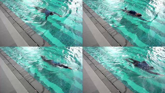 一名亚洲女孩以慢动作的方式在游泳池游泳锻炼